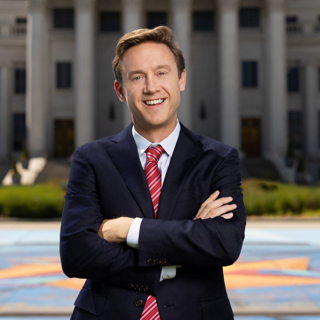 A headshot of Mayor Mike Johnston with nature and buildings in the background.